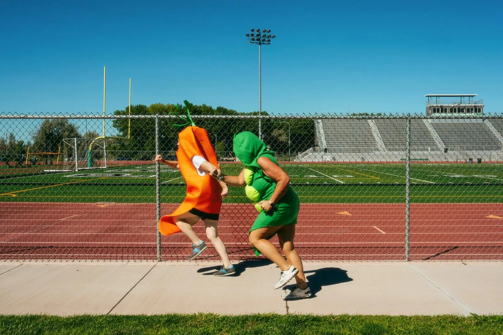 Carrot and pea pod runners training on a stadium running track