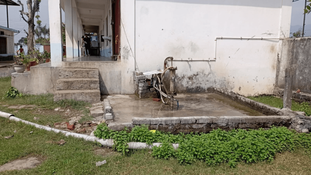Image of an old waterwell against a white wall.