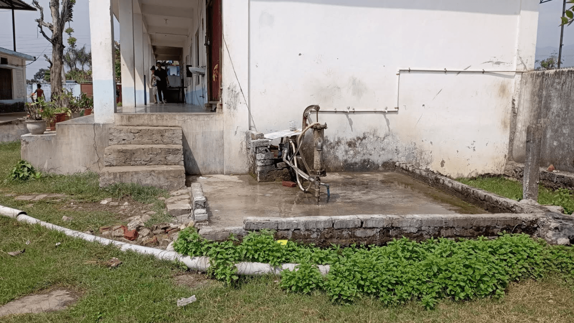 Image of an old waterwell against a white wall.